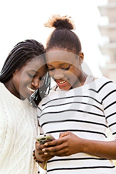 African teen girls texting on smart phone.