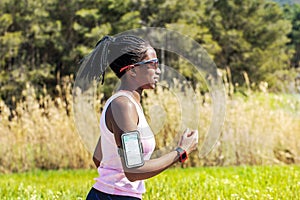 African teen running with fitness activity tracker.