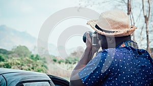 African tourists stand happily photographing mountains and landscapes.Adventure travel concept