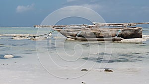 African Traditional Wooden Boat Stranded in Sand on Beach at Low Tide, Zanzibar