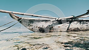 African Traditional Wooden Boat Stranded in Sand on Beach at Low Tide, Zanzibar