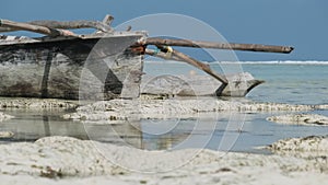 African Traditional Wooden Boat Stranded in Sand on Beach at Low Tide, Zanzibar