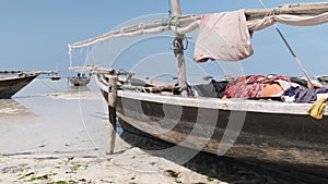 African Traditional Wooden Boat Stranded in Sand on Beach at Low Tide, Zanzibar