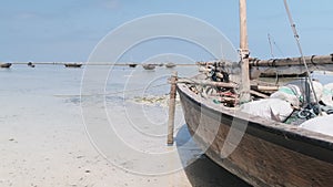 African Traditional Wooden Boat Stranded in Sand on Beach at Low Tide, Zanzibar