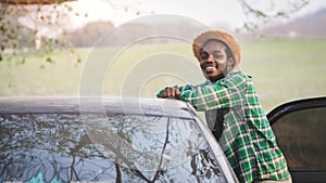 African traveler man is enjoying beautiful landscape during summer adventure in mountain at sunset. Travel car concept