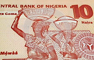 African tribal native motif with women carrying basket loads on head on Nigeria 10 Naira currency banknote