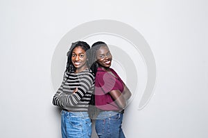 African two women standing back to back not speaking to each other on white background