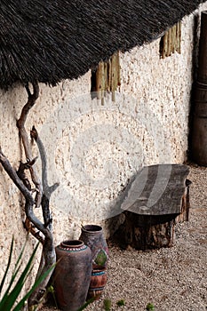 African village outdoor scene empty bench and pots straw roof