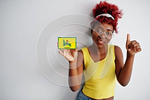 African woman with afro hair hold Ogun flag isolated on white background, show thumb up. States of Nigeria concept photo