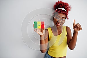 African woman with afro hair, wear yellow singlet and eyeglasses, hold Senegal flag isolated on white background, show thumb up photo