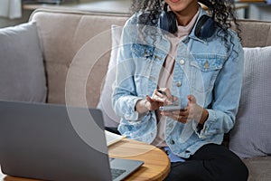 African woman, American, using laptop computer and wearing headphones for online learning