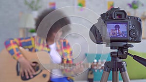 African woman blogger with an afro hairstyle with a guitar the view through the camera screen