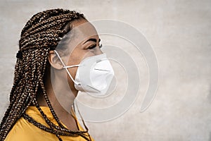 African woman with braids wearing face medical mask - Young girl using facemask for preventing and stop corona virus spread