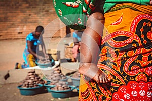 African woman is carrying her baby on the market