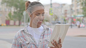 African Woman Celebrating Success on Tablet Outdoor