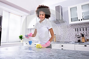 African Woman Cleaning Kitchen Counter