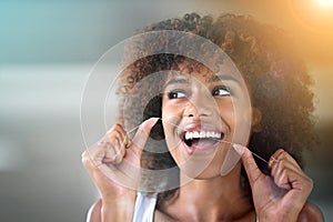 African woman, dental floss and happy for cleaning for oral wellness, health or benefits for mouth in bathroom. Girl