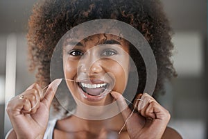 African woman, dental floss and happy in portrait for oral wellness, health and benefits for mouth in bathroom. Girl