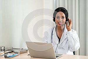 African woman doctor in headset taking calling on her headset