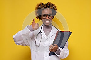 African woman doctor smiling at camera showing thumb up