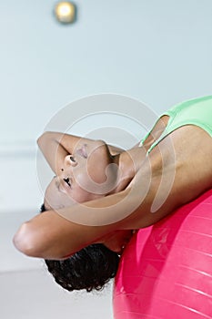 African woman doing series of sit-ups in gym