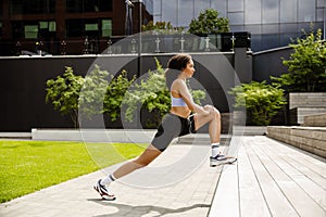 African woman doing stratching exercises during workout outdoors