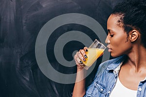 African woman drink orange juice. Healthy life.