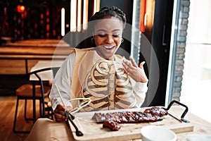 African woman eat spicy hot grilled spare ribs