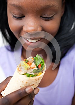 African woman eating a fajita