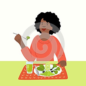 African woman eating green vegetables.