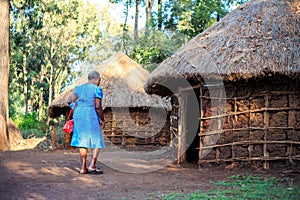 African woman entering a traditional Kenyan house