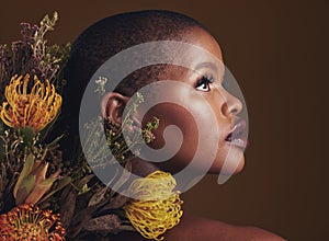 African woman, flowers and studio profile for beauty, wellness or thinking with vision by brown background. Girl, model