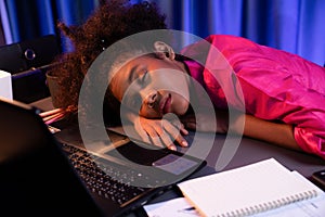 African woman freelancer feeling tried and take a nap on desk. Tastemaker.