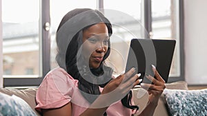African woman having video call on tablet pc