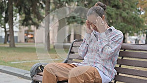 African Woman with Headache Sitting Outdoor on Bench