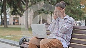 African Woman with Headache Using Laptop while Sitting Outdoor on Bench