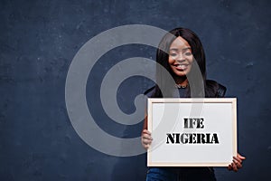 African woman hold white board with Ife Nigeria inscription. Most populous city in Africa concept