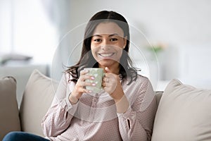 African woman holding cup enjoy coffee pause at home