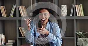 African woman holding smartphone reading great sms news feels happy