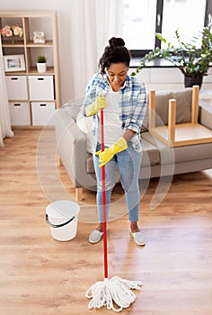 African woman or housewife cleaning floor at home