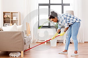 African woman or housewife cleaning floor at home