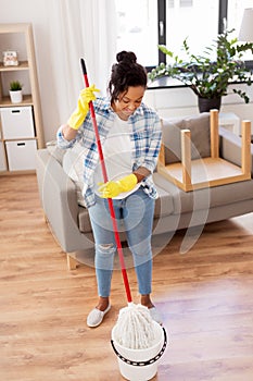 African woman or housewife cleaning floor at home