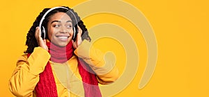 African Woman Listening To Music In Earphones Over Yellow Background