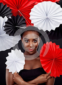 African woman, origami fans and portrait with art deco for creative makeup by dark background. Culture fusion, beauty