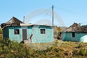 African woman out of her traditional mud house in South Africa. Apartheid, zululand KwaZulu-Natal