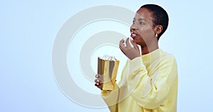 African woman, popcorn and laugh in studio, comedy and happy with mockup space by blue background. Girl, cinema or