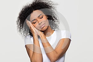 African woman pretending sleeping with head on hands eyes closed