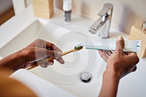 African woman put tooth paste on ecological toothbrush