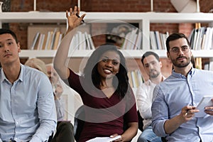 African woman raising hand to ask question at team training