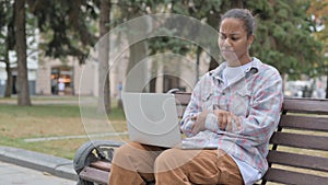 African Woman Reacting to Loss on Laptop while Sitting Outdoor on Bench